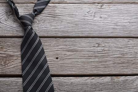 Simple Black Tie on Wooden Surface Used for Dressing in Formal Occasionsの写真素材