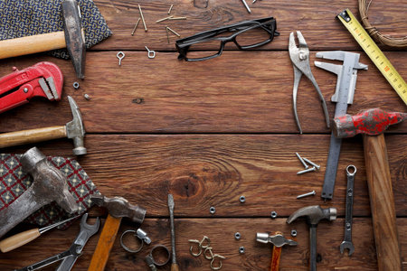Collection of Tools and Equipment on Wooden Surface for Various Tasks in a Workshop Setting
