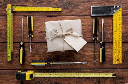 Tools and Materials Arranged Around a Wrapped Package on a Wooden Surfaceの写真素材