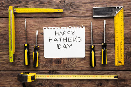 Fathers Day Celebration With Tools Arranged Around a Card on a Wooden Table
