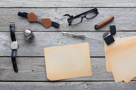 Collection of Various Office Supplies and Personal Items on a Wooden Table in Daylightの写真素材