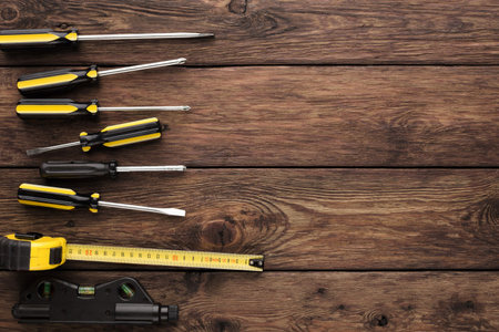 Tools Arranged on Wooden Surface for Home Repair and Maintenance Tasksの写真素材