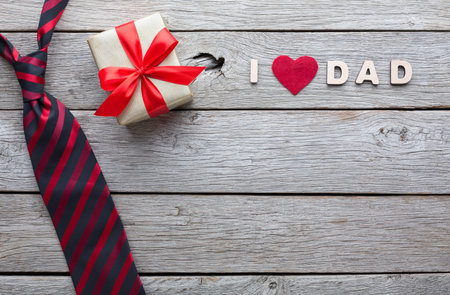 Gift and Message for Dad on Wooden Table With Tie and Presentの写真素材