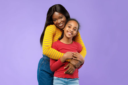 Mother and Daughter Pose Together With Smiles Against a Purple Backgroundの写真素材