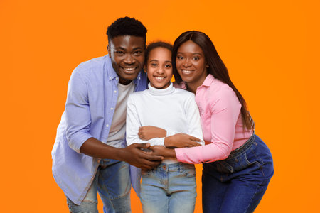 Family Smiles Together in Front of Bright Orange Backdrop During a Fun Moment