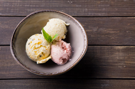 Three Scoops of Ice Cream in a Bowl on a Wooden Table