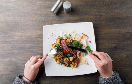 Eating a Delicious Meal With Fresh Ingredients at a Dining Table in a Casual Settingの写真素材
