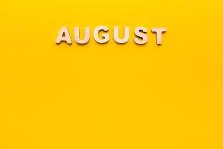 Colorful Display of the Month August on a Bright Yellow Backgroundの写真素材