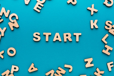 Wooden Letters Arranged Around the Word Start on a Blue Background During a Creative Activityの写真素材