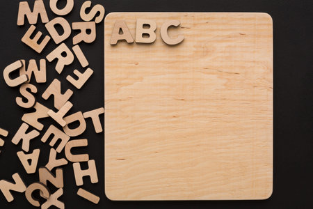 Wooden Letters Scatter Around Plain Board With ABC on Top During a Craft Session