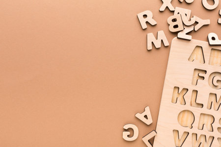 Wooden Letters Are Scattered Next to a Board With Shaped Cutouts for Each Letter