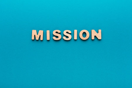 Wooden Letters Spell out Mission on a Blue Background in a Simple Arrangement
