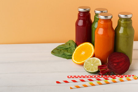 Variety of Fresh Juices in Bottles With Fruits and Vegetables on Wooden Table