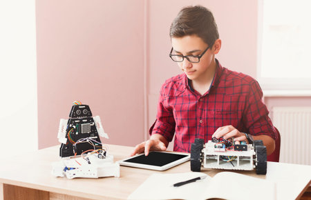 Student Works on Robotics Project and Uses Tablet for Programming and Control