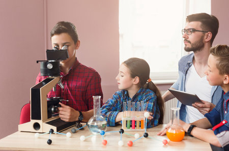 Students Learn About Science and Have Fun Using a Microscope in a Classroom During the Afternoon