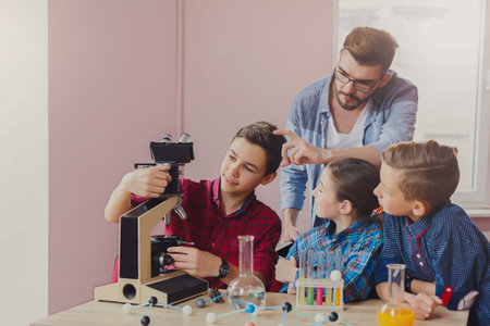 Students Learn About Microscopes During a Science Class in a Bright Classroom Settingの写真素材