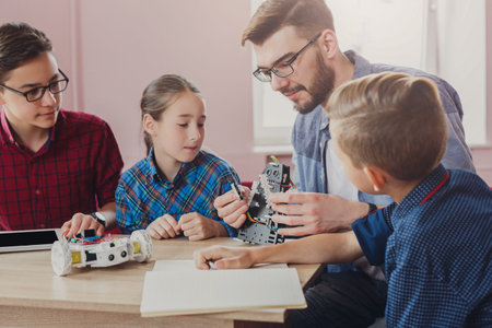 Children Learn About Robotics With Instructor in Classroom Setting During Daytime
