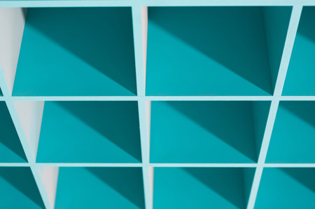 Shelving Unit With Turquoise Compartments and Clear Shadows on a White Wallの写真素材