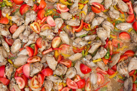 Cooking Chicken With Vegetables in a Large Pan During a Gathering Outside on a Warm Dayの写真素材