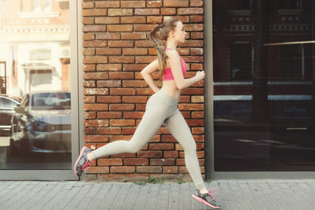 Running in the City on a Sunny Day With a Brick Wall Backdrop