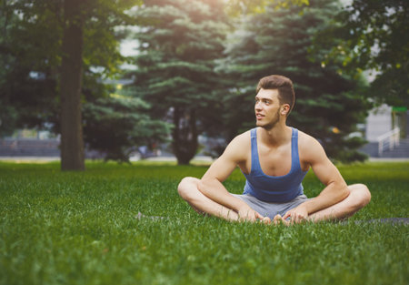 Man Practicing Yoga in a Green Park During Daylight Hours