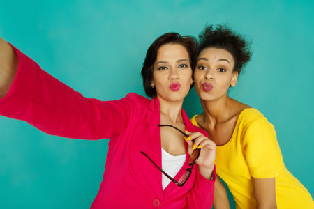 Friends Take a Selfie Together Against a Bright Blue Background in a Cheerful Setting