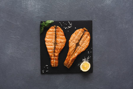 Grilled Fish Served on a Black Plate With Herbs and Lemon in a Kitchen Setting
