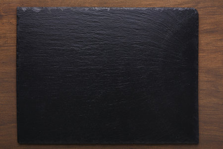 Black Slate Pieces Arranged on a Wooden Table for Events and Gatherings