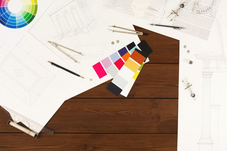 Collage of Design Sketches, Color Samples, and Drawing Tools on a Wooden Table