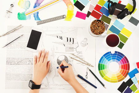 Crafting Designs in a Creative Workspace With Tools and Materials Organized in a Mosaic Layout