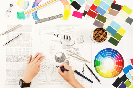 Creative Process in Collage Art With Color Charts and Sketches on a Workspace Table