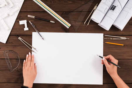 Collection of Tools and Materials for Architectural Drawing and Planning on a Wooden Table