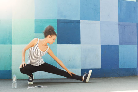 Stretching and Warming up by a Colorful Wall in the Morning Sun