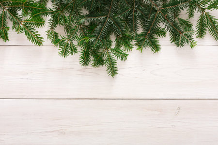 Fresh Green Branches on a Light Wooden Surface During the Festive Season in Winter