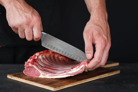 Chef Prepares Meat With Knife on Cutting Board in Kitchen
