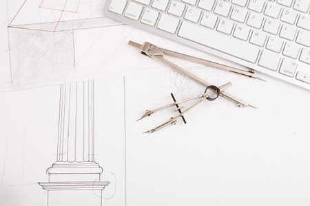 Collection of Drawing Tools and Architectural Sketches on a Workspace With Computer Keyboard