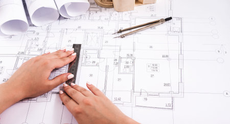 Construction Project Plan With Hands Using a Ruler and Tools on Detailed Drawings and Blueprints