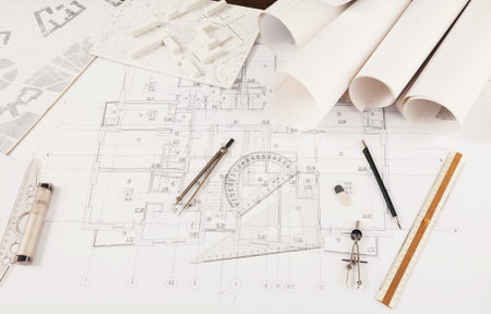 Collage of Architectural Plans and Drafting Tools on a Workspace Table