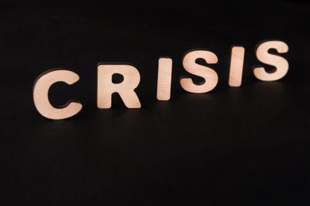 Wooden Letters Spell out the Word Crisis on a Dark Background During a Creative Activityの写真素材