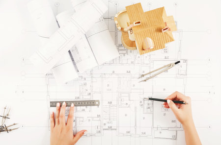 Detailed Design Process for a Building With Plans and a Model on a Work Table