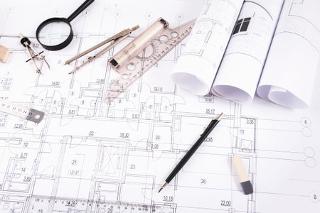 Collection of Blueprints and Drafting Tools on a Workspace Table for Design Projects
