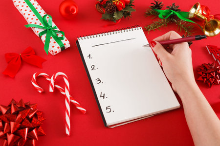 Creating a Holiday Gift List With Decorations and Gifts on a Red Surface in a Festive Setting