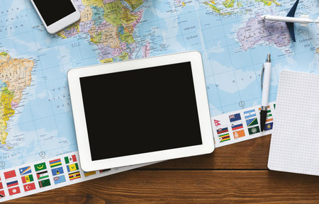 Tablet with blank screen laying on world map