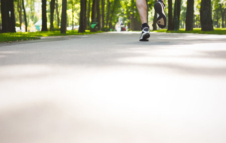 Runner Moves Quickly Along a Path in a Green Park During Daytime