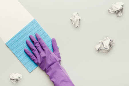 Cleaning Process With Purple Glove and Supplies on a Simple Surface With Waste Items