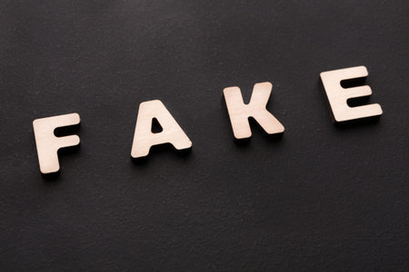 Words Are Arranged to Spell Fake on a Dark Surface With No Other Objects Aroundの写真素材