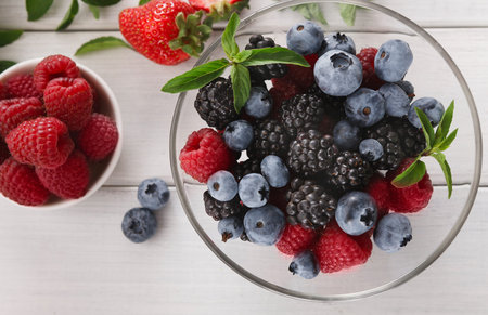 Fruit Collage With Various Berries Arranged in a Bowl and a Small Bowl of Raspberries