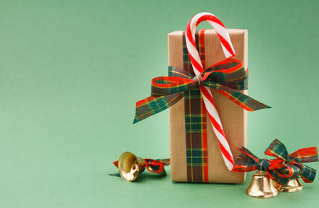 Gift Box With Decorations and Candy Canes on Green Background During Holiday Season