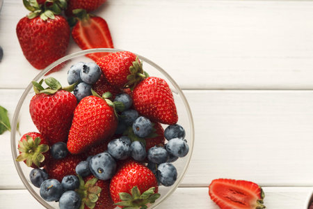 Collection of Fresh Strawberries and Blueberries in a Bowl on a Wooden Surface