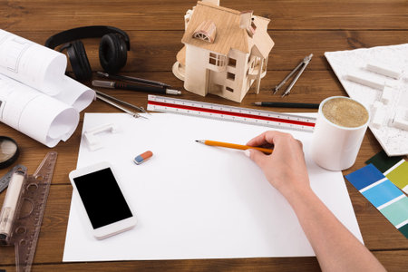 Sketching House Designs at a Workspace With Tools and Materials for a Creative Project